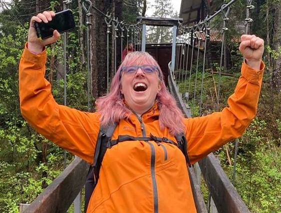 Fi on a high bridge, joyfully shouting at the sky close up